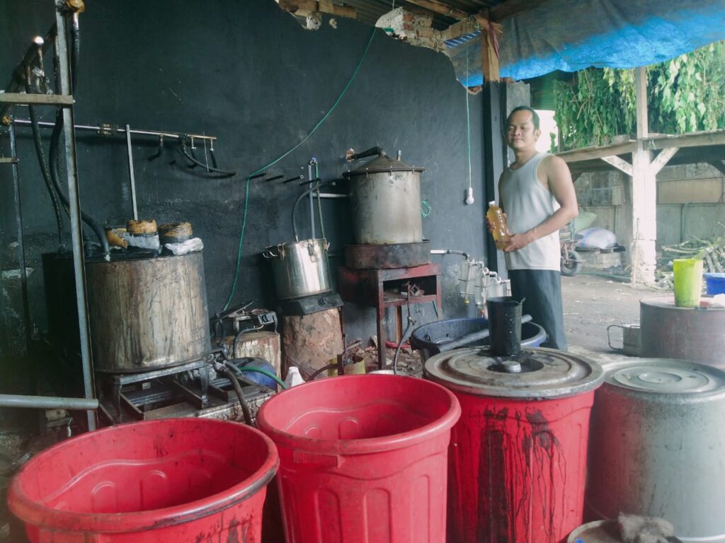 Andriyono di tempat penyulingan sambil memegang produk minyak atsiri (Kiss FM Jember/Rusdi)
